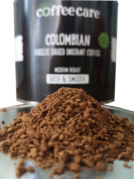 a pile of Coffee Care's Colombian Freeze Dried Instant Coffee. 500g of arabica coffee. Medium roast, rich and smooth. Tin blurred out in background